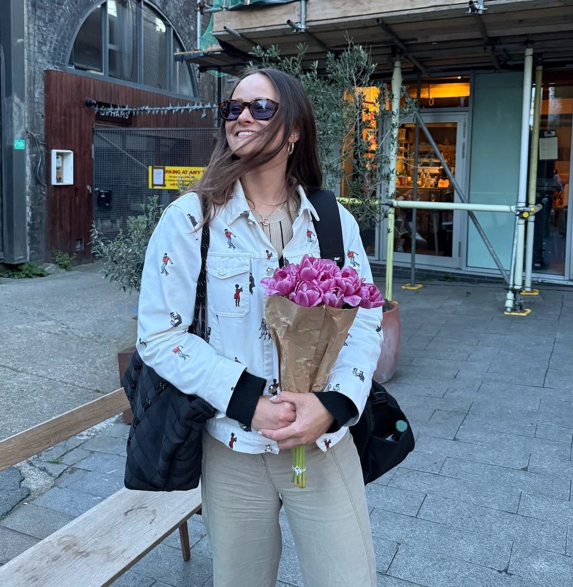 Charlotte Rubesa holding a bunch of pink tulips